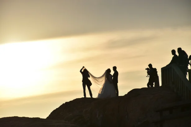 Couple getting photos taken after their wedding with a sunset in the background.